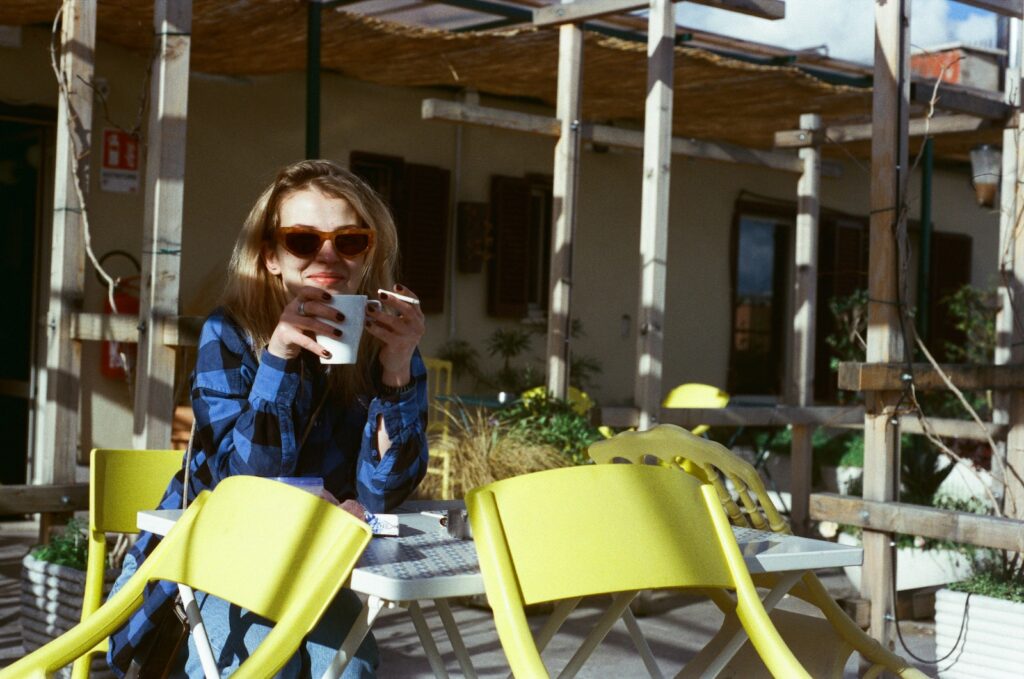 a woman sitting at a table with a cup of coffee